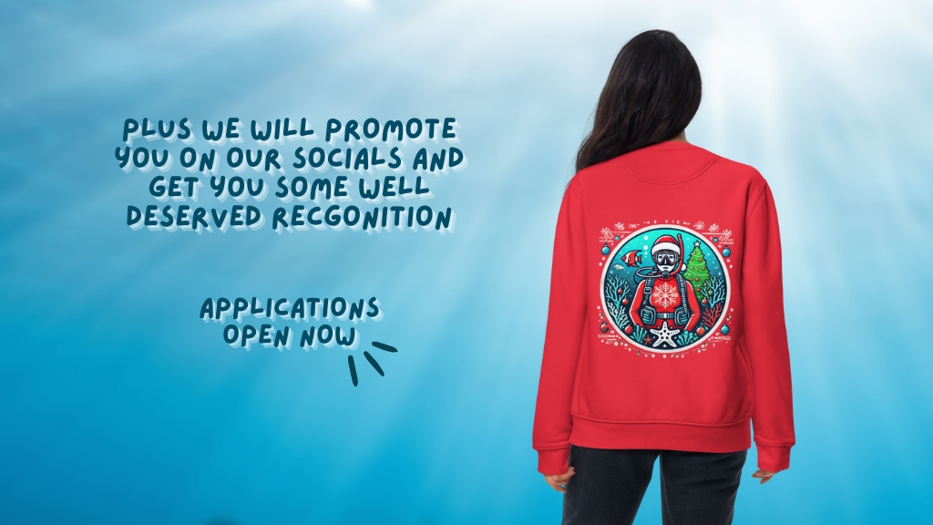 A woman is facing away from the camera, wearing a red sweatshirt with a christmas-themed scuba diver motif on the back. Overlaid text reads "Plus we will promote you on our socials and get you some well deserved recognition. Applications open now"